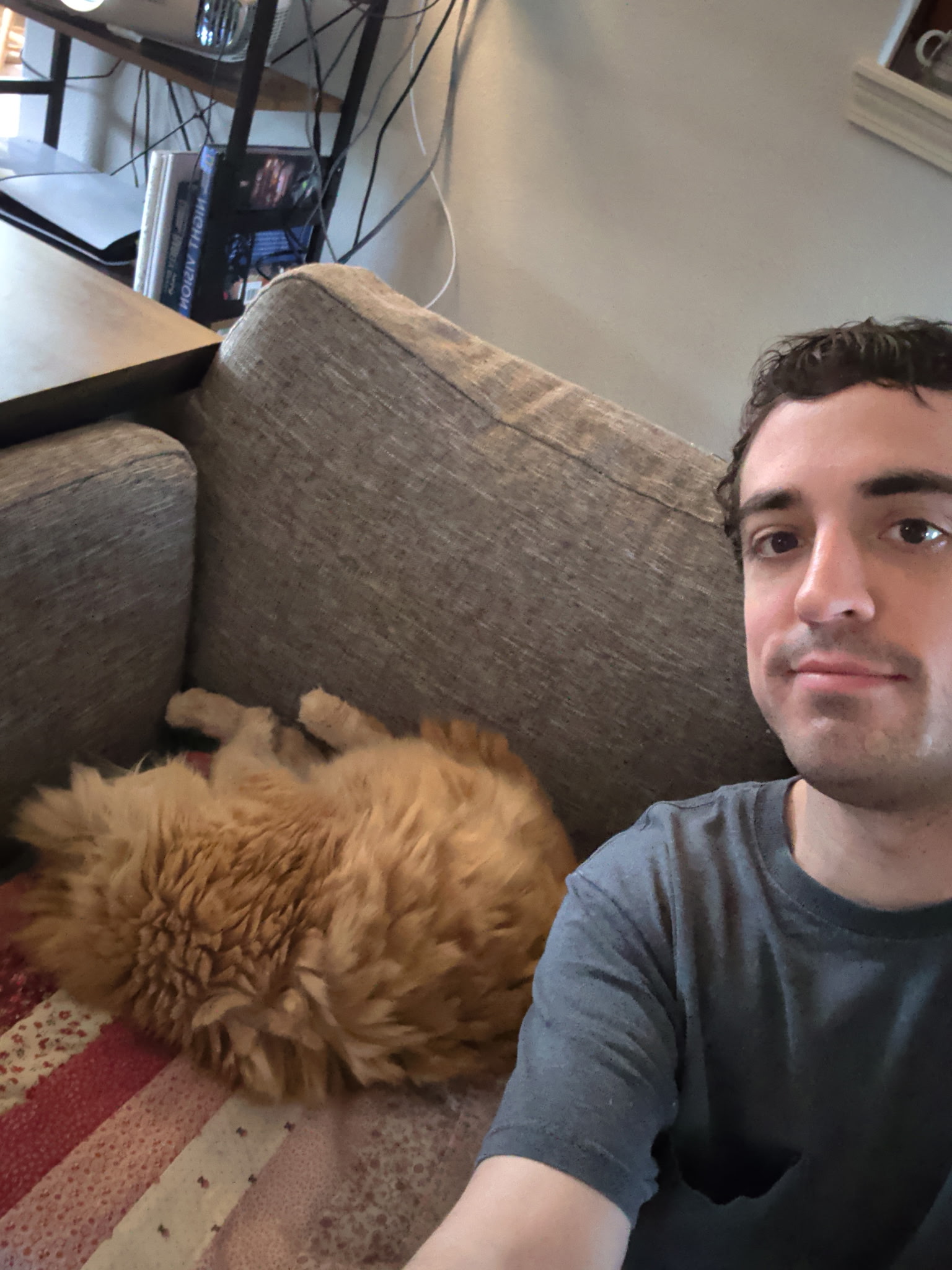 Andrew on the couch with Garfield the orange cat napping beside him